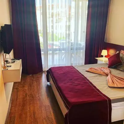 a bedroom with a large bed with a large window at Apartment on the Beach in Sveti Vlas