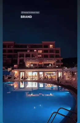 a hotel with a large swimming pool at night at Apartment on the Beach in Sveti Vlas
