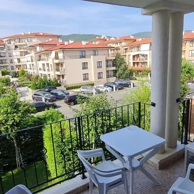 a balcony with a table and chairs and a parking lot at Apartment on the Beach in Sveti Vlas