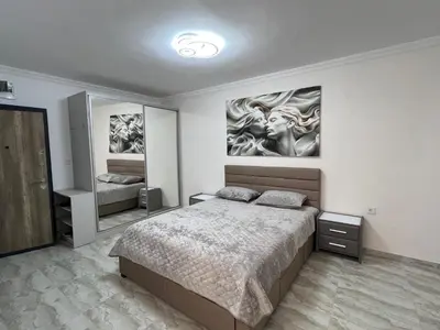 a bedroom with a large bed and two mirrors at Студия Магнолия 6, Солнечный берег Болгария in Sunny Beach
