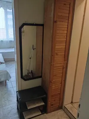 a bathroom with a mirror and a wooden closet at Апартамент планина in Varna City