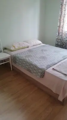 a bed in a bedroom with a wooden floor at Апартамент център in Varna City