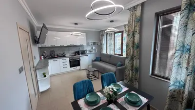 a kitchen and a living room with a table and chairs at Paradise in Burgas City