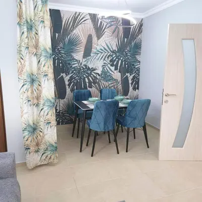 a dining room with a table and blue chairs at Paradise in Burgas City