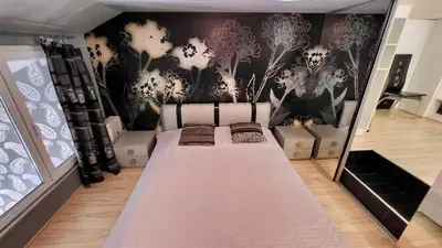 a room with a bed with a wall with skulls at Комфорт и стиль - Апартамент с панорамой города in Burgas City