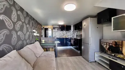 a living room with a couch and a kitchen at Комфорт и стиль - Апартамент с панорамой города in Burgas City