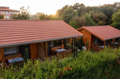 a log cabin with a red roof and trees at Бунгала Гнездото Bungalows The Nest Lozenets 2 in Lozenets