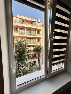 a window with a view of a building at Sun in Varna City