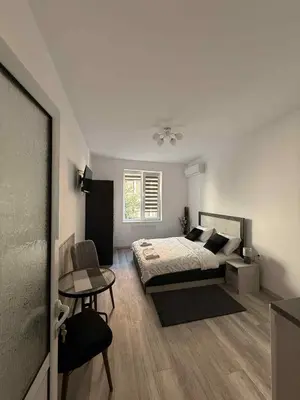 a bedroom with a bed and a table and a chair at Sun in Varna City
