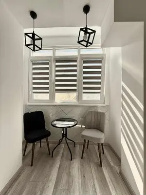a dining room with two chairs and a table and a window at Sky in Varna City