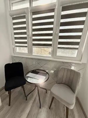 a room with two chairs and a table and windows at Sky in Varna City