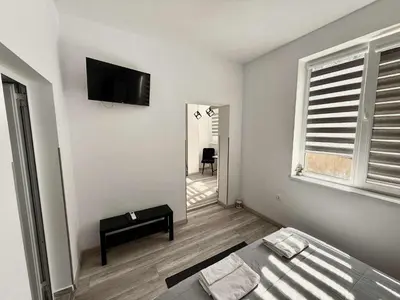 a white room with a bed and a television on the wall at Sky in Varna City