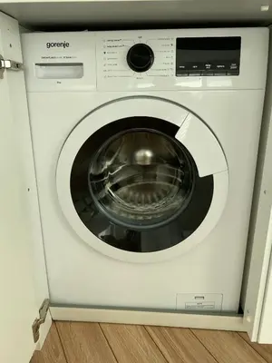 a white washing machine is in a room at The Corner Studio in Varna City