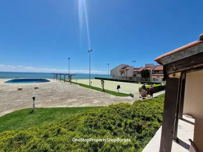 a view of a beach with a building and the ocean at Ravda Holiday Village 1-bed seaview apartment in Ravda