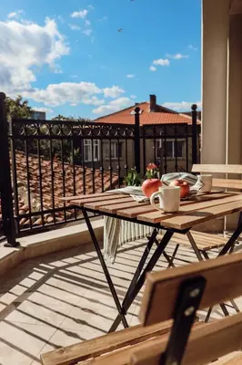 a wooden table sitting on a balcony with a tableablish at Central Varna Stay with Free Parking by ApartMAX in Varna City