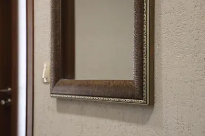 a mirror on a wall with a wooden frame at Central Varna Stay with Free Parking by ApartMAX in Varna City
