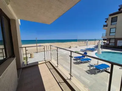 a balcony with a view of the beach and a swimming pool at Апартамент E003 в Обзор Бийч Резорт - усещането да живееш на плажа !!! in Obzor