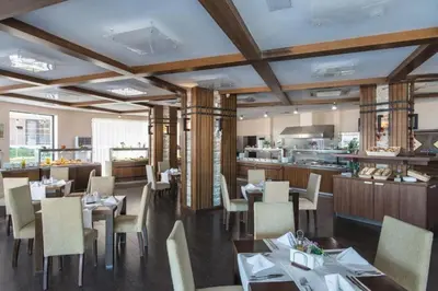 a restaurant with tables and chairs and a kitchen at Апартамент E003 в Обзор Бийч Резорт - усещането да живееш на плажа !!! in Obzor
