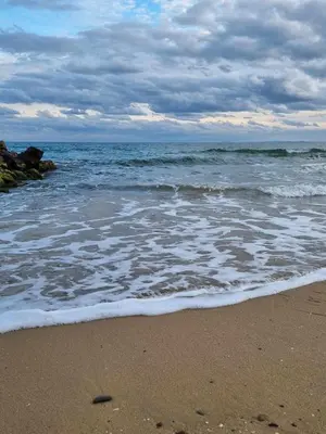 a beach with the ocean on a cloudy day at Fort Noks Grand Resort Wave&Dreams in Sveti Vlas