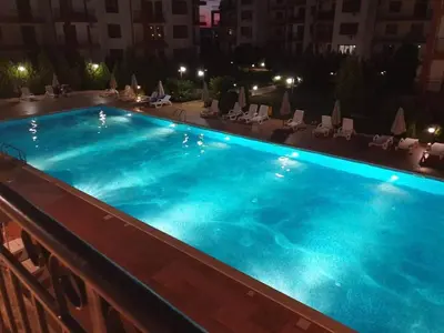 a large blue swimming pool on a balcony at night at Fort Noks Grand Resort Wave&Dreams in Sveti Vlas