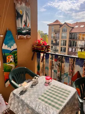 a table on a balcony with a view of a building at Студия Авангард in Sunny Beach