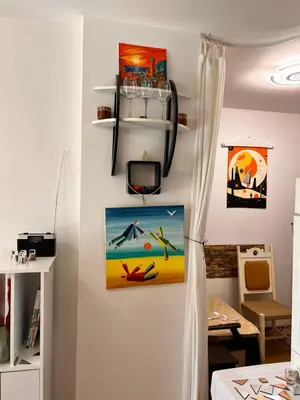 a room with a wall with a painting and a tv at Студия Авангард in Sunny Beach
