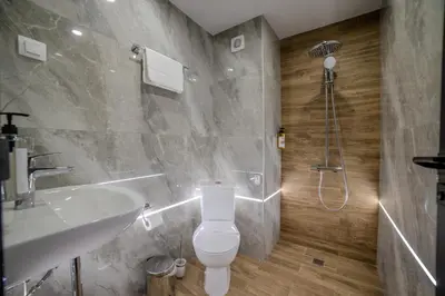 a bathroom with a toilet and a sink and a shower at Aslan Gold Hotel in Varna City