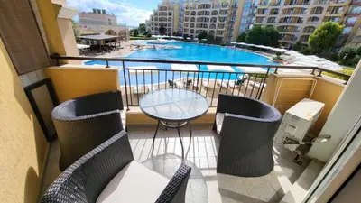 a balcony with a table and chairs and a swimming pool at Studio F210 - Bulharsko in Aheloy