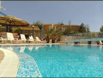 a large swimming pool with chairs and a bridge at Елегантно Студио В18 в комплекс Одисей, Несебър in Burgas City