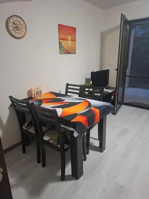 a dining room table and chairs with an orange and black blanket at The White Houses 7 in Nesebar