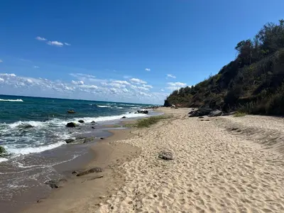 a beach with footprints in the sand and the ocean at Eco Apartment Cliff in Obzor