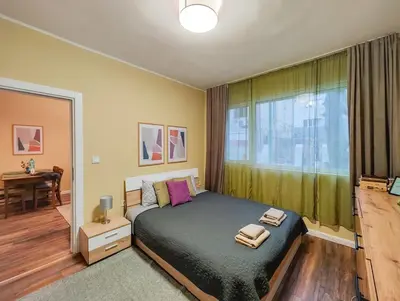 a bedroom with a large bed and a window at PasTelo - 6 min to the Beach & Promenade in Varna City