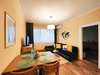 a living room with a table and a couch at PasTelo - 6 min to the Beach & Promenade in Varna City