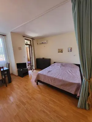 a bedroom with a bed and a wooden floor at Garden of Eden studio in Sveti Vlas