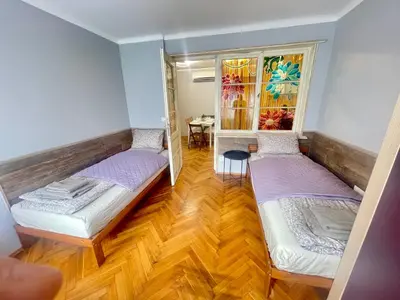 two beds in a room with a table at 'Golden Bird' Apartment, 2 Bedrooms, Super Central in Burgas City