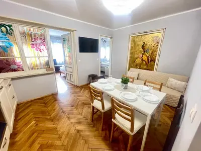 a dining room with a white table and chairs at 'Golden Bird' Apartment, 2 Bedrooms, Super Central in Burgas City