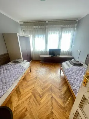 a room with two beds and a desk with a laptop at 'Golden Bird' Apartment, 2 Bedrooms, Super Central in Burgas City