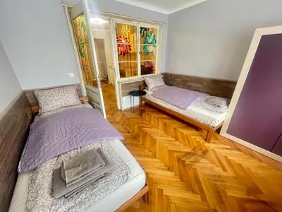 two beds in a room with wooden floors at 'Golden Bird' Apartment, 2 Bedrooms, Super Central in Burgas City