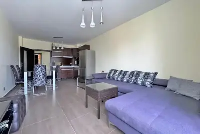 a living room with a purple couch and a kitchen at Apartments Nessebar in Nesebar