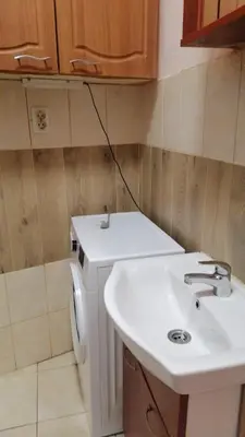 a bathroom with a sink and a washing machine at апартамент Климент in Varna City