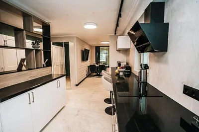 a kitchen with white cabinets and a black counter top at The Loft - Parking - Washer&Dryer - Port view - Balcony in Burgas City