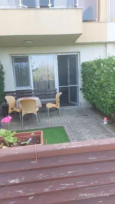 a patio with a table and chairs in front of a building at Апартамент Феличита in Byala