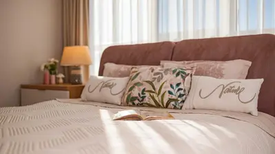 a bedroom with a bed with a book on it at Harmony Delux Apartment -Free parking in Burgas City