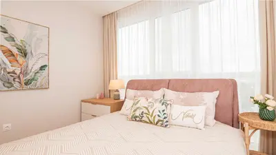 a bedroom with a bed with pillows and a window at Harmony Delux Apartment -Free parking in Burgas City