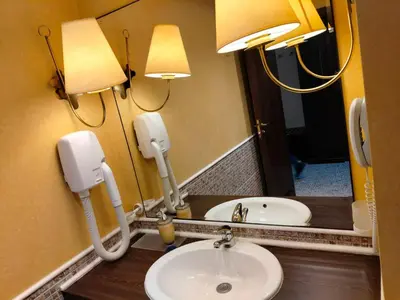 a bathroom with a sink and two lights and a mirror at Studio Royal Beach Barcello in Sunny Beach