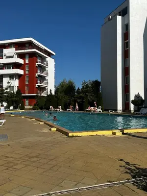 a swimming pool with people in the water and buildings at Have a Good Rest Apartments in Sveti Vlas