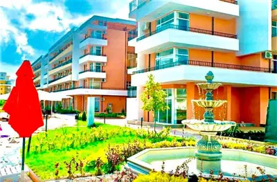 a building with a fountain in front of a building at Grand Kamelia Apartments Sunny Beach in Sunny Beach