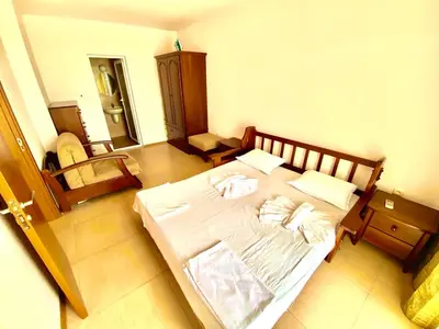 a bedroom with a large white bed in a room at Grand Kamelia Apartments Sunny Beach in Sunny Beach