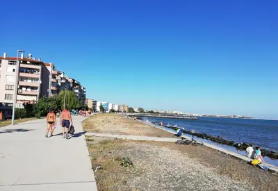 a group of people walking along the beach at Sunny Day Apartment in Pomorie