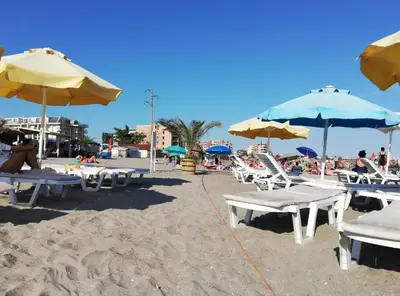 a group of chairs and umbrellas on a beach at Sunny Day Apartment in Pomorie